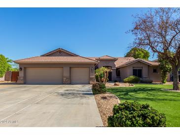 Two-story house with three-car garage and landscaped lawn at 10913 N 153Rd Ln, Surprise, AZ 85379