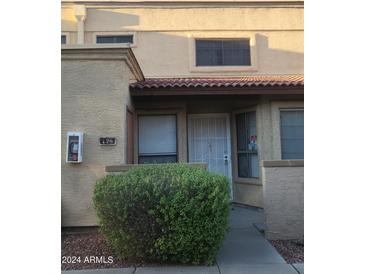 Tan stucco condo building with entryway and landscaping at 4608 W Maryland Ave # 126, Glendale, AZ 85301