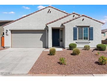 Front view of a single-story house with a two-car garage and landscaping at 15112 W Hadley St, Goodyear, AZ 85338