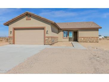 Tan house exterior with stone accents and a two-car garage at 36366 W Whitton Ave, Tonopah, AZ 85354