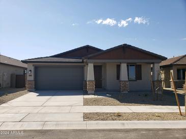 One story home with gray garage door and stone accents at 20542 N 226Th Ln, Surprise, AZ 85387