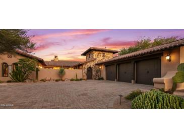 Three-car garage with stone and stucco exterior at 36975 N Mirabel Club Dr, Scottsdale, AZ 85262