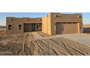 Newly constructed home with stucco exterior, attached garage, and walkway at 38422 W Buckeye Rd, Tonopah, AZ 85354