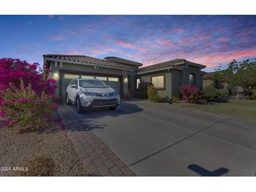 House exterior at dusk, showcasing landscaping and driveway at 16449 W Shangri La Rd, Surprise, AZ 85388