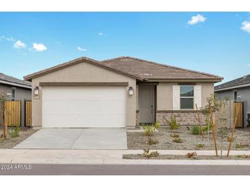 One-story home with tan exterior, white garage door, and landscaping at 16074 W Cottontail Ln, Surprise, AZ 85387