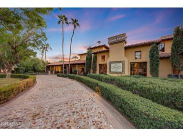 Tuscan-style home with a stone driveway and manicured landscaping at 6107 E Paradise Dr, Scottsdale, AZ 85254