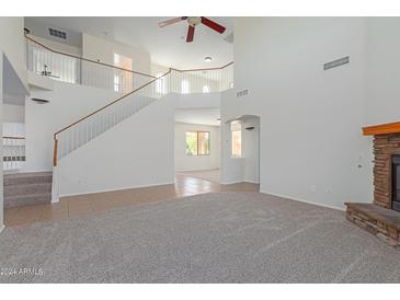 Two-story living room with staircase and views to other rooms at 40752 W Robbins Dr, Maricopa, AZ 85138