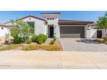 Single-story home with a two-car garage and landscaped yard at 12075 N San Clemente St, Surprise, AZ 85388