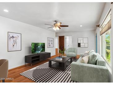 Living room with hardwood floors, ceiling fan, and lots of natural light at 930 E San Juan Ave, Phoenix, AZ 85014