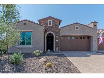 Single-story home with brick facade and two-car garage at 16917 W Sheridan St, Goodyear, AZ 85395