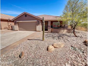 Single-story home with two-car garage and desert landscaping at 563 S 230Th Ave, Buckeye, AZ 85326