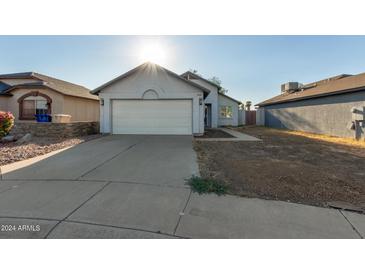 Single-story house with white garage door and landscaping at 7394 N 67Th Dr, Glendale, AZ 85303