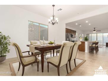 Open concept dining room with adjacent kitchen and breakfast bar at 13618 W Shifting Sands Dr, Peoria, AZ 85383