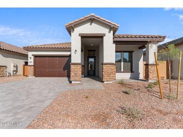 One-story home with brown garage door, stone accents, and landscaped yard at 682 E Aurora Dr, San Tan Valley, AZ 85140