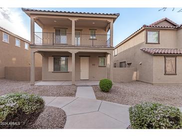 Two-story house with balcony, neutral colors, and landscaping at 931 E Agua Fria Ln, Avondale, AZ 85323