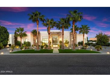 Modern house exterior with palm trees and an elegant entryway at 24351 N 97Th Dr, Peoria, AZ 85383