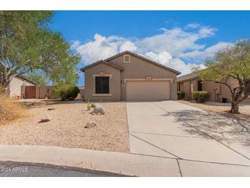 Tan house with two-car garage and desert landscaping at 6599 E Casa De Leon Ln, Gold Canyon, AZ 85118