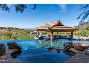 Infinity pool with a built-in bar and stunning panoramic mountain views at 15972 N 115Th Way, Scottsdale, AZ 85255