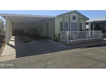 Mobile home with carport and small fenced patio at 8700 E University Dr # 1931, Mesa, AZ 85207