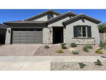 One-story home with gray siding, stone accents, and landscaping at 15922 W Electra Ln, Surprise, AZ 85379