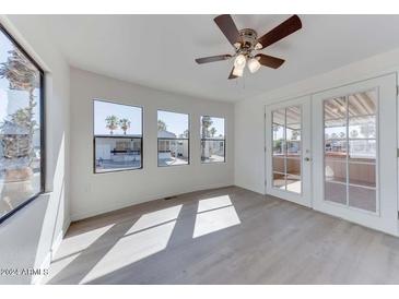 Bright living room with wood-look floors, large windows, and ceiling fan at 17200 W Bell Rd # 450, Surprise, AZ 85374