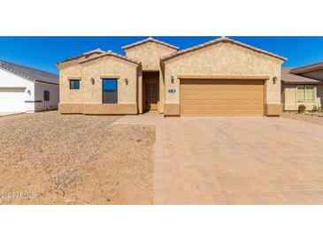 Tan stucco home with a two-car garage and landscaped yard at 9290 W Troy Dr, Arizona City, AZ 85123