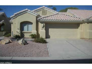 Tan colored house with a two car garage and desert landscaping at 5830 E Mckellips Rd # 62, Mesa, AZ 85215