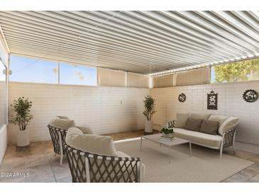 Covered patio with white brick walls and seating at 10038 W Hawthorn Dr, Sun City, AZ 85351