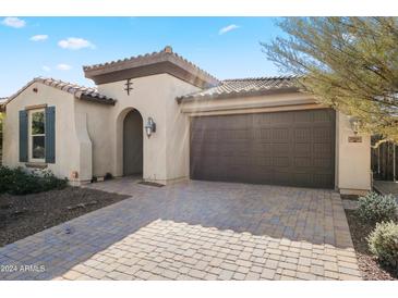 Home's exterior showcases a two-car garage and attractive landscaping at 20461 W Briarwood Dr, Buckeye, AZ 85396