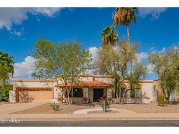 Single-story home with a tile roof, landscaped yard, and a two-car garage at 1736 N Ashbrook Cir, Mesa, AZ 85213