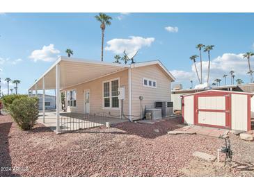 Rear view showing covered patio, shed, and landscaping at 7300 N 51St Ave # D212, Glendale, AZ 85301