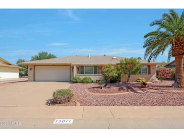 Ranch-style home with a two-car garage and landscaping at 13011 N 98Th Ave, Sun City, AZ 85351