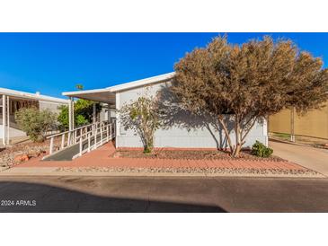 Mobile home with ramp access, mature trees, and a paved driveway at 2650 W Union Hills Dr # 54, Phoenix, AZ 85027