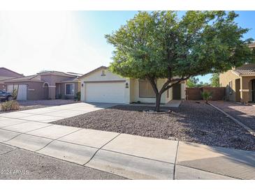 Single-story home with attached garage and mature tree at 16193 W Calavar Rd, Surprise, AZ 85379