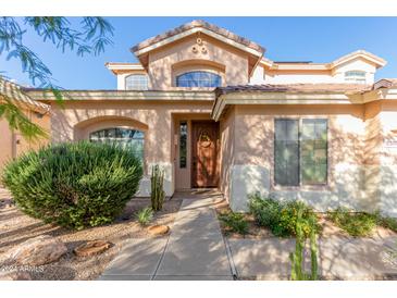 Inviting front entrance with a wooden door and landscaping at 2320 W Forest Pleasant Pl, Phoenix, AZ 85085