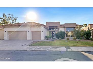 Modern home with a neutral color scheme, two car garage, and well-manicured lawn at 12028 N 80Th Pl, Scottsdale, AZ 85260