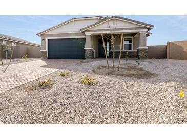 Inviting single-story home with a paved driveway, landscaping, and desert front yard at 17583 W Jefferson St, Goodyear, AZ 85338