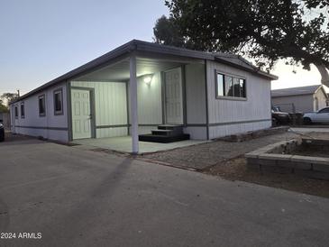 Mobile home with covered porch and landscaped yard at 9017 E Butternut Ave, Mesa, AZ 85208