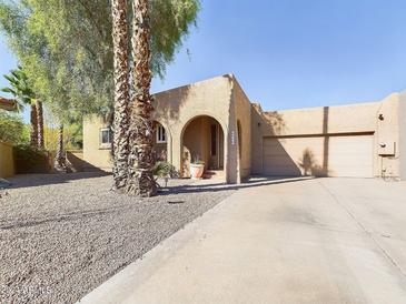 Charming single-story home with a gravel driveway and mature palm trees at 14679 N Love Ct, Fountain Hills, AZ 85268