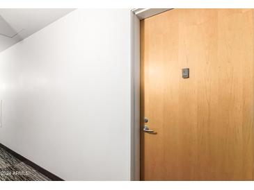 Apartment hallway with light walls and wood door at 7117 E Rancho Vista Dr # 2005, Scottsdale, AZ 85251
