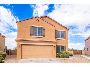 Two-story house with tan exterior and double garage at 18774 N Ibis Way, Maricopa, AZ 85138