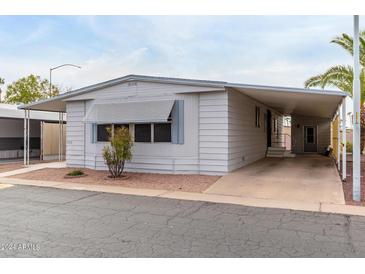 Single-wide manufactured home with carport and landscaping at 205 S Higley Rd # 288, Mesa, AZ 85206