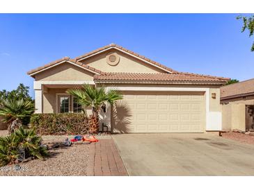 One-story home with tan exterior and two-car garage at 8010 W Adam Ave, Peoria, AZ 85382