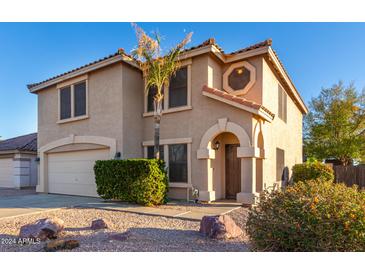 Two-story house with a tan stucco exterior and a two-car garage at 8143 E Obispo Ave, Mesa, AZ 85212