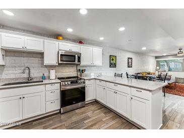 Updated kitchen with white shaker cabinets and stainless steel appliances at 27250 N 64Th St # 1, Scottsdale, AZ 85266