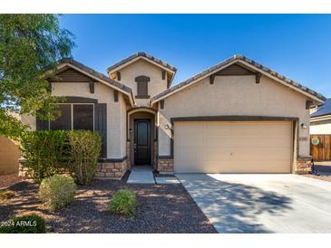 Single-story home with two-car garage and desert landscaping at 1952 N 212Th Ln, Buckeye, AZ 85396