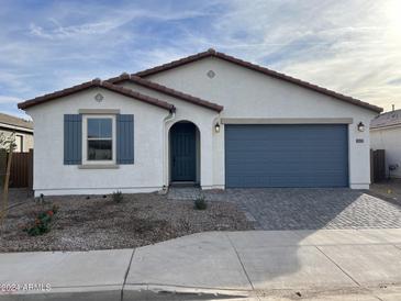 New single-story home with gray garage door and landscaping at 40549 W Wade Dr, Maricopa, AZ 85138