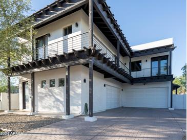 Modern home exterior with a two-car garage and a covered patio at 1004 E Tempe Dr, Tempe, AZ 85281