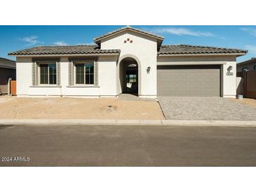 Single-story home with arched entryway, neutral color palette, and paved driveway at 3636 W Summerside Rd, Laveen, AZ 85339