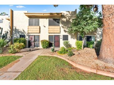 Two-story condo building exterior with landscaping and walkway at 4620 N 68Th St # 136, Scottsdale, AZ 85251